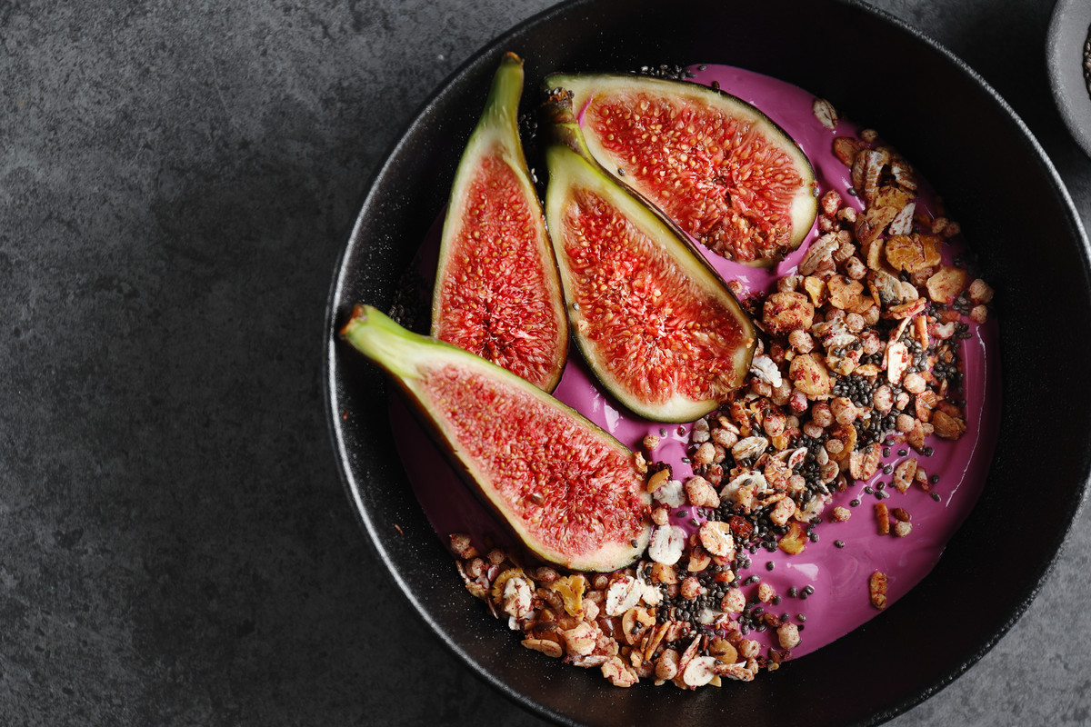 Fruity bowl with muesli granola and figs served in bowl.